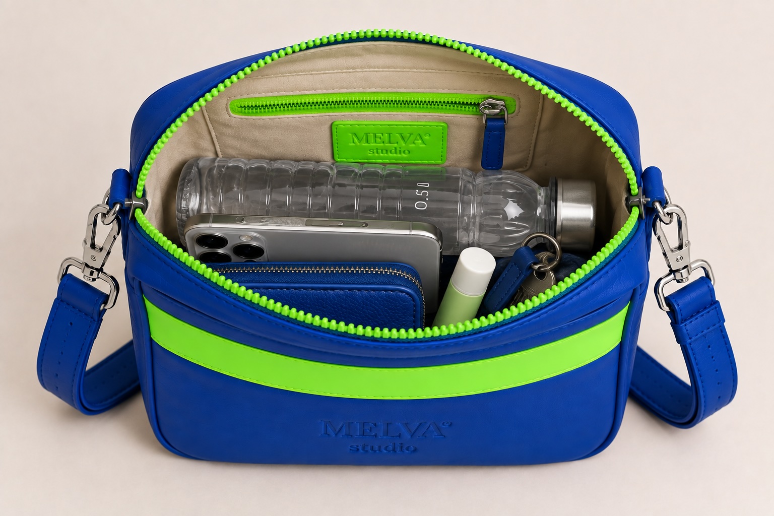 Blaue MELVA° Studio Crossbody Bag mit 0,5-l-Wasserflasche, Smartphone und Schlüssel