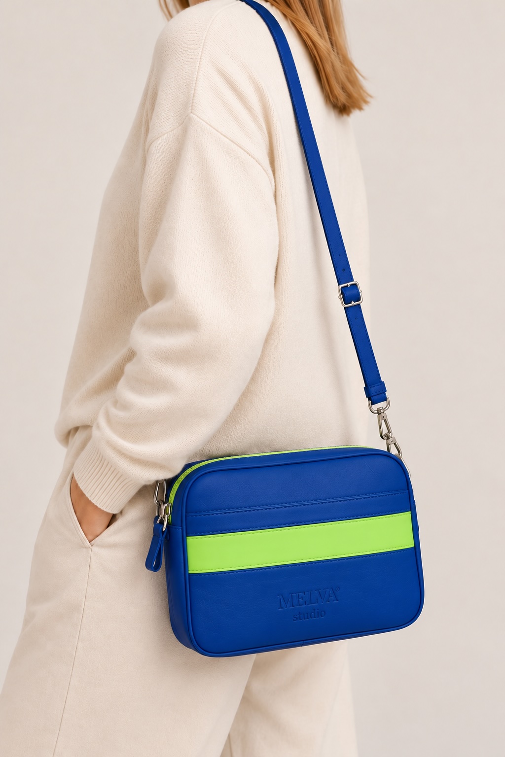 Frau mit blauer MELVA° Studio Crossbody Bag mit grünem Akzent